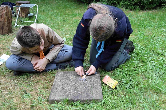 Pfadfinderin beim Funkenschlagen um Feuer zu machen