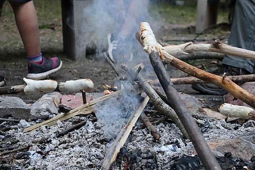 Stockbrot wird über einem Feuer geröstet.