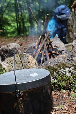 Kochen, einfach, lecker, nahrhaft. Ein Hordentopf vor einem brennenden Feuer